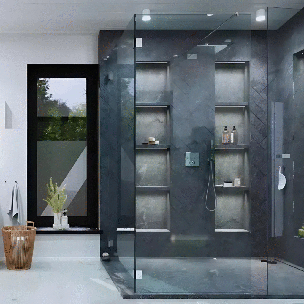Moderne badkamer met glazen douche en zwarte tegels.